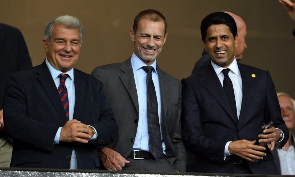 Tres dirigentes de fútbol sonriendo en evento