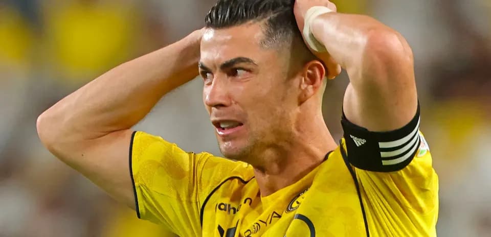 Jugador con camiseta amarilla sosteniendo la cabeza en el campo