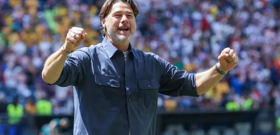 Entrenador celebrando durante el partido en estadio