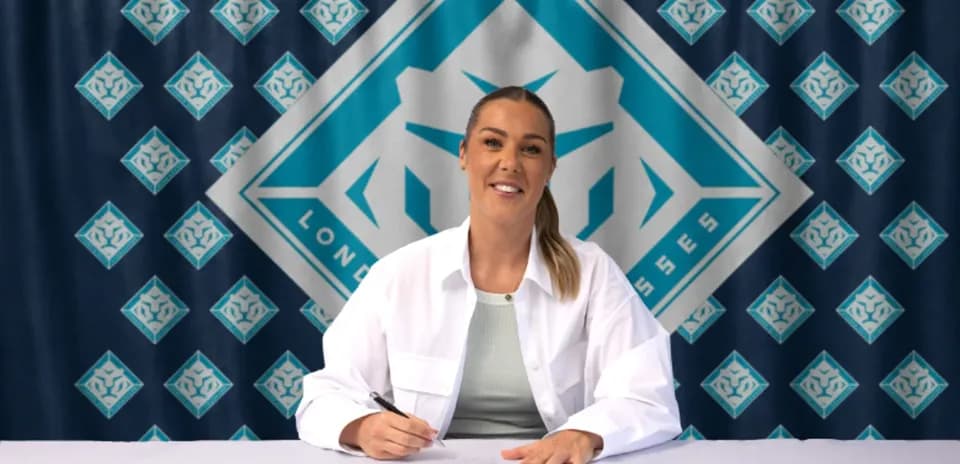 Jugadora firmando contrato en mesa con logo de equipo