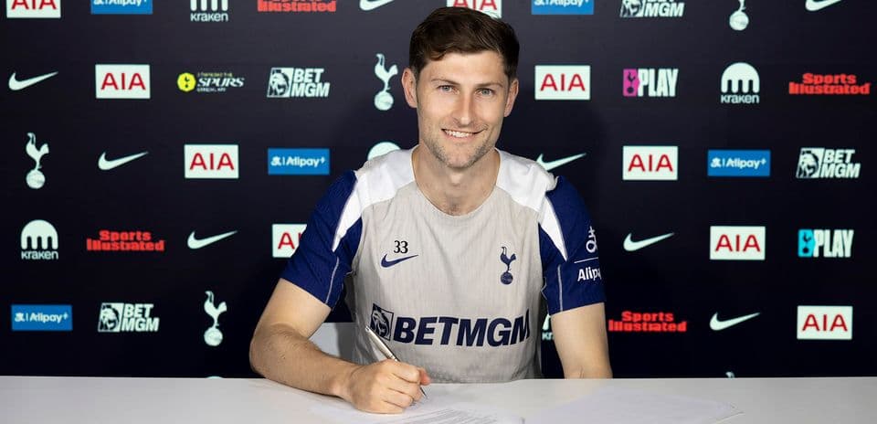 Jugador firmando contrato en mesa de prensa