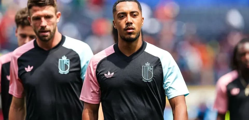 Jugadores entrando al campo con camisetas de entrenamiento
