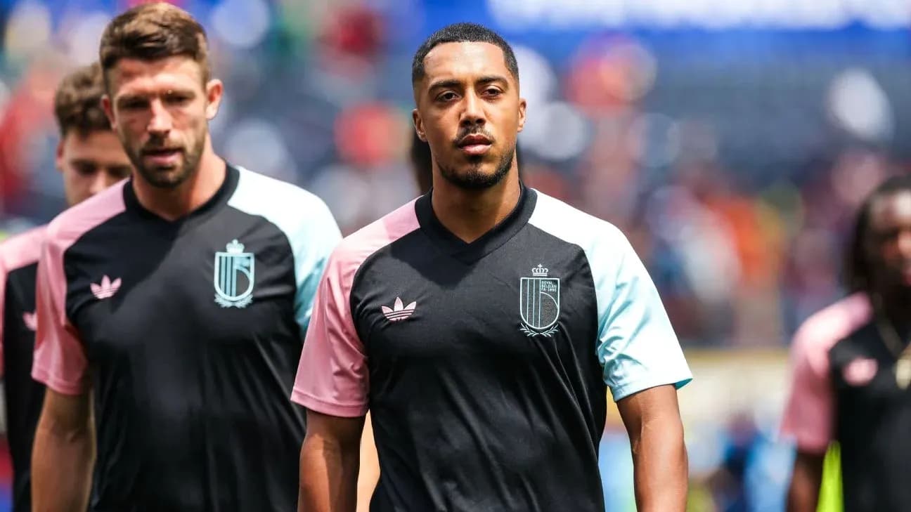Jugadores entrando al campo con camisetas de entrenamiento