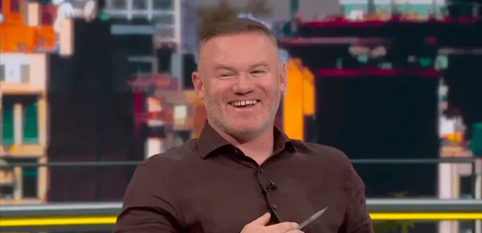 Hombre sonriendo en un set de televisión deportivo