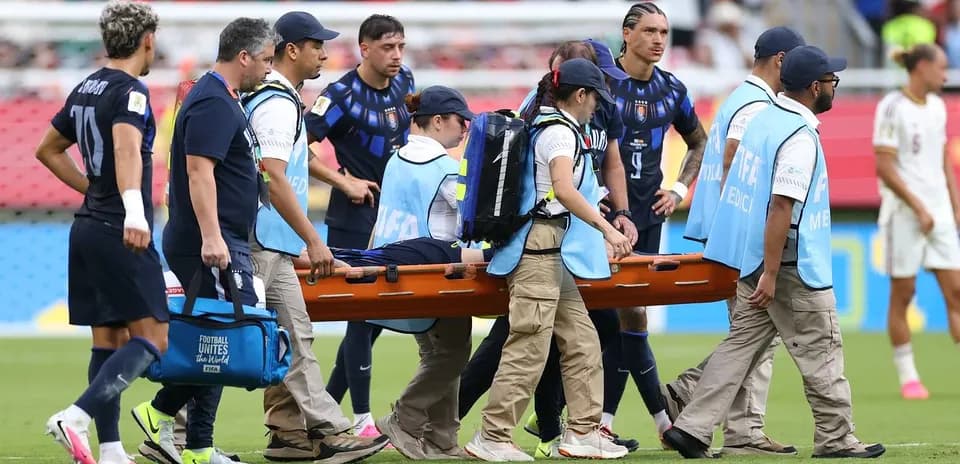 Jugadores y personal médico trasladando a un jugador herido