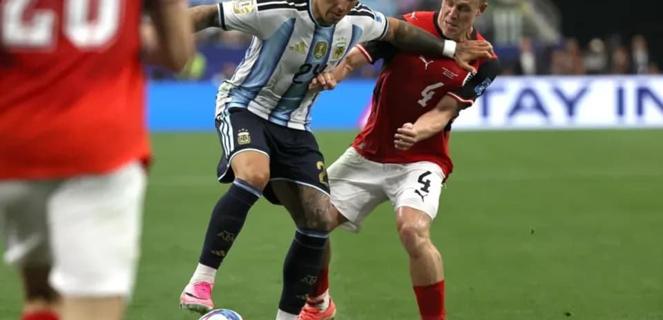 Jugador de Argentina lucha por el balón con rival