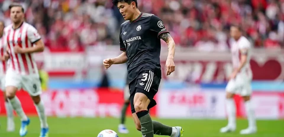 Jugador driblando el balón en el campo de fútbol