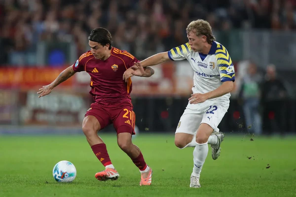 Jugador de AS Roma desafiando a un oponente de Parma Jugador de AS Roma desafiando a un oponente de Parma