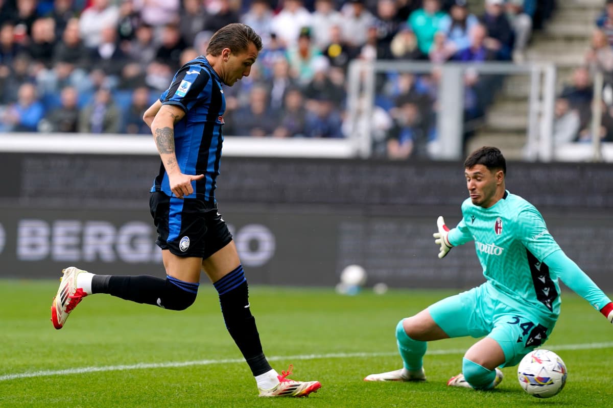 Jugador de Atalanta frente al portero de Bologna Jugador de Atalanta frente al portero de Bologna