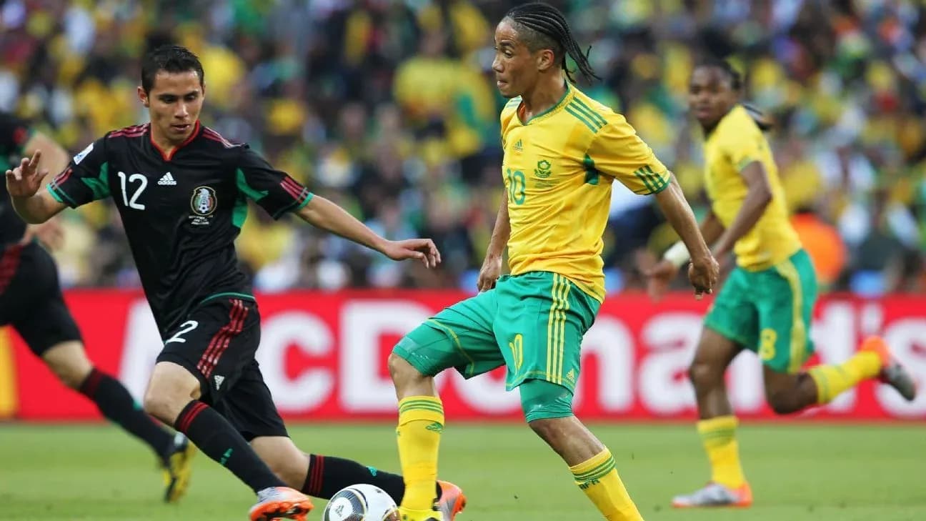Jugador sudafricano driblando a jugador mexicano en partido Jugador sudafricano driblando a jugador mexicano en partido