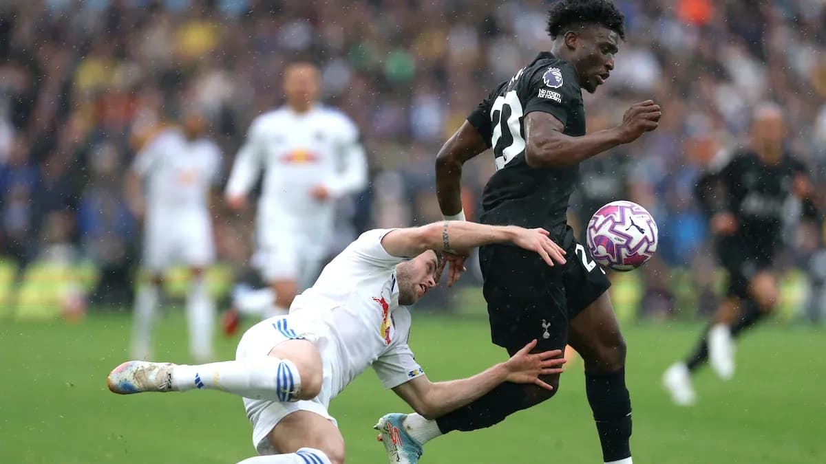 Jugador de Tottenham esquivando a un oponente caído Jugador de Tottenham esquivando a un oponente caído