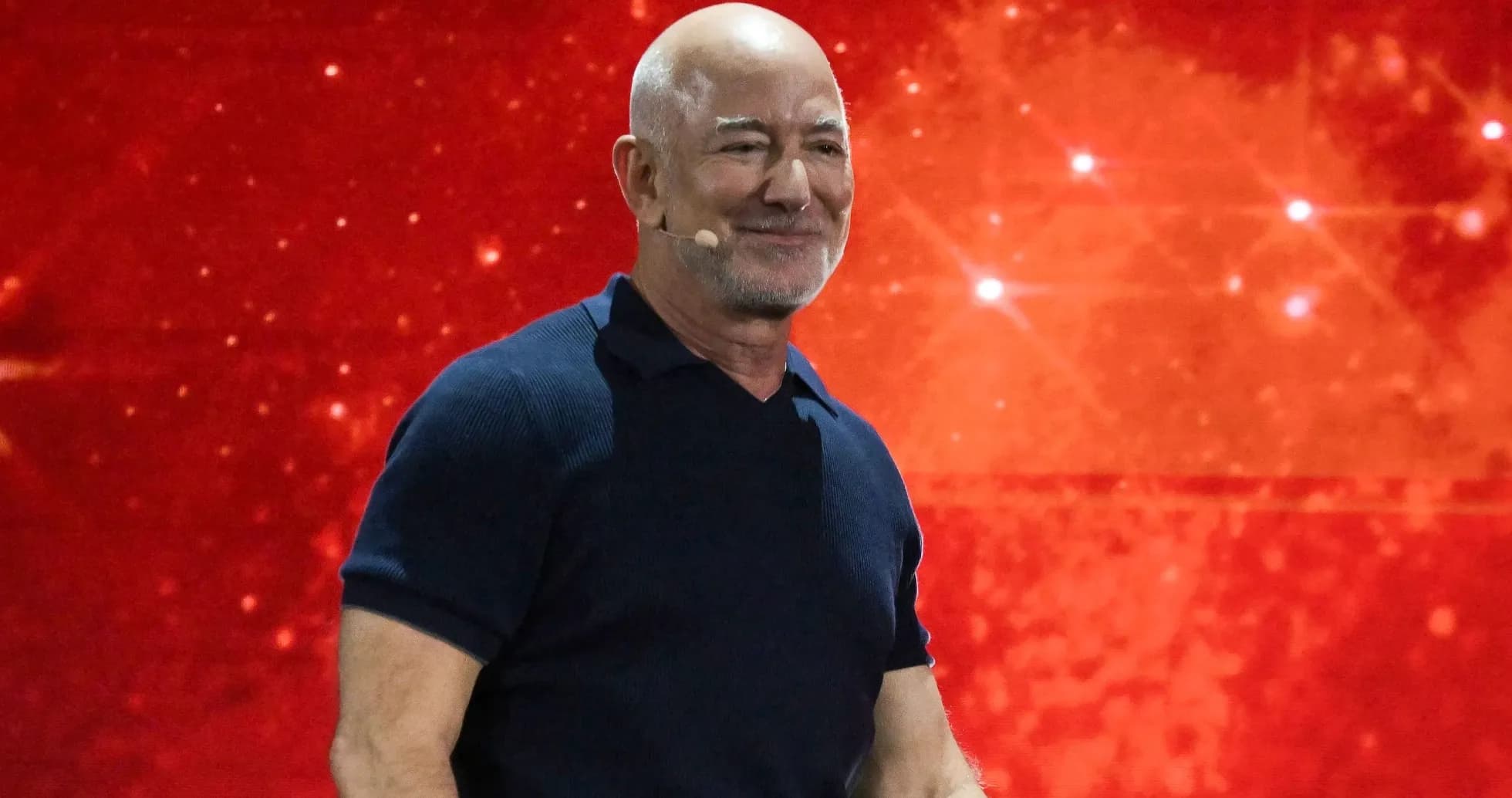 Hombre sonriente en un escenario con fondo rojo Hombre sonriente en un escenario con fondo rojo