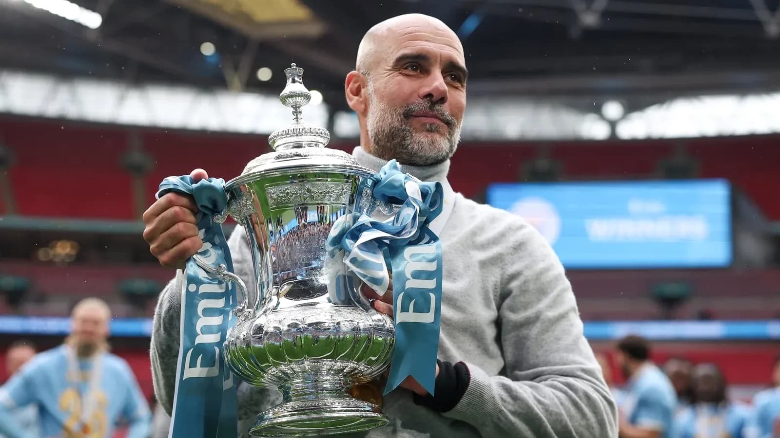 Entrenador sosteniendo el trofeo en el estadio Entrenador sosteniendo el trofeo en el estadio