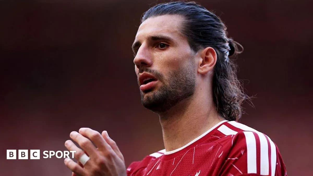 Jugador de fútbol con camiseta roja en acción Jugador de fútbol con camiseta roja en acción