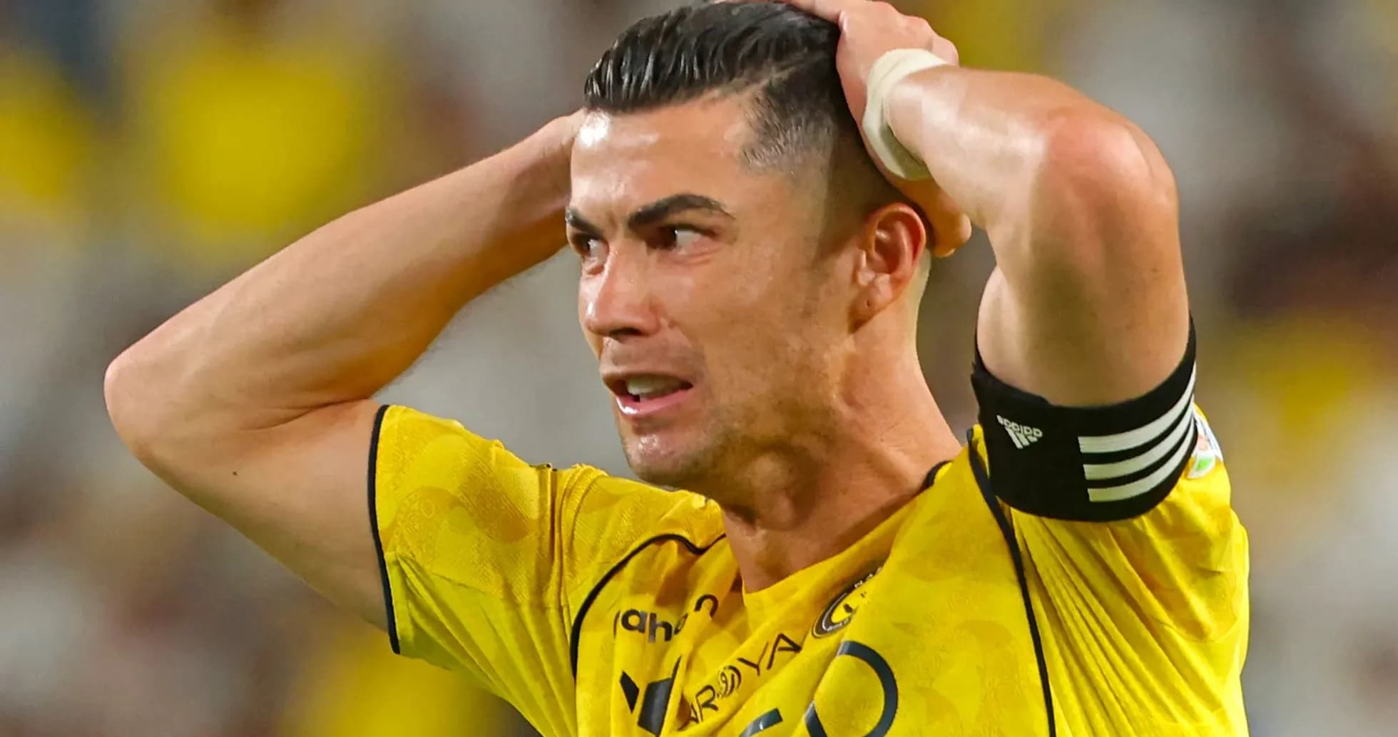 Jugador con camiseta amarilla sosteniendo la cabeza en el campo Jugador con camiseta amarilla sosteniendo la cabeza en el campo