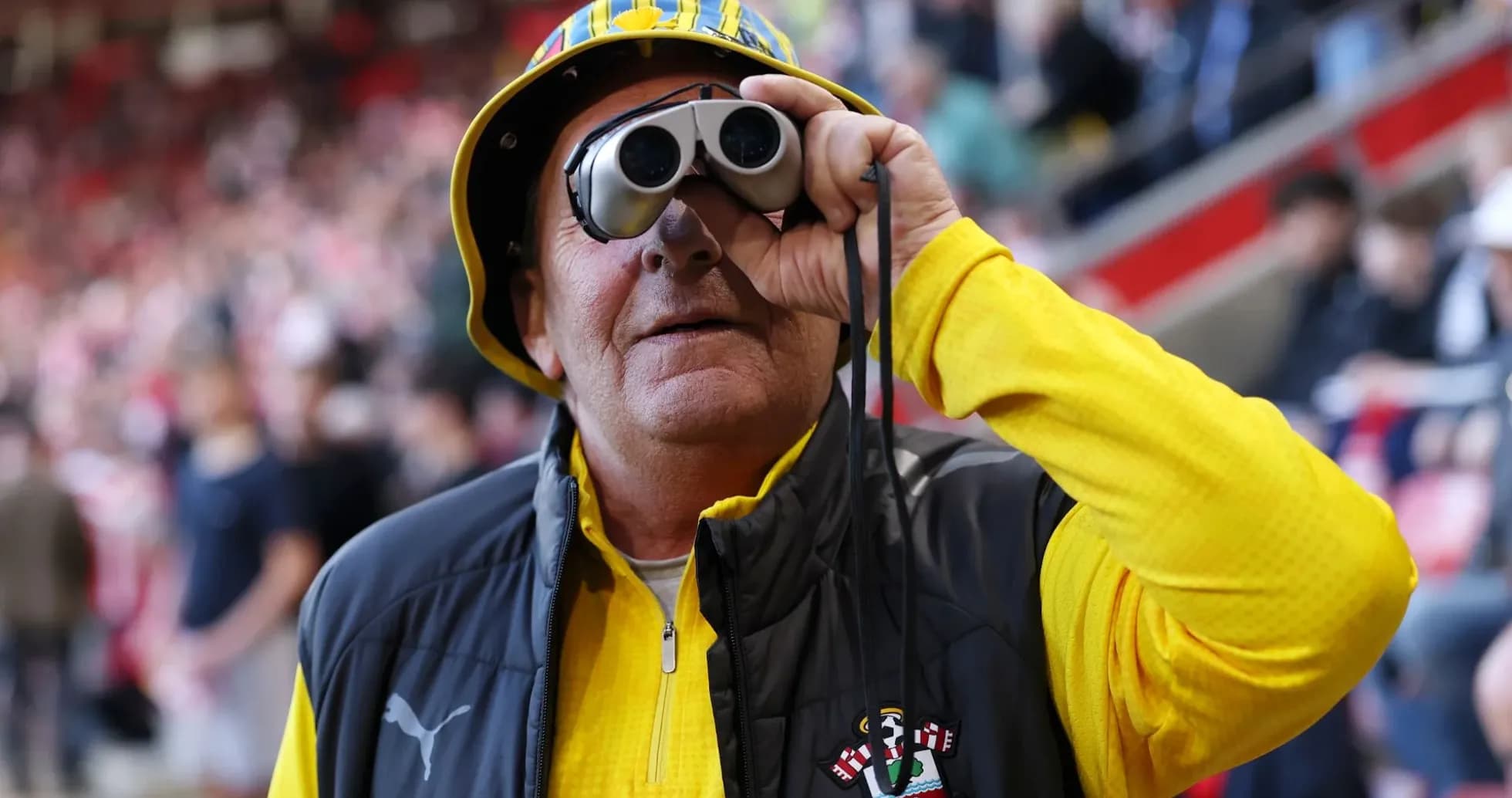 A fan wearing binoculars at a football match A fan wearing binoculars at a football match