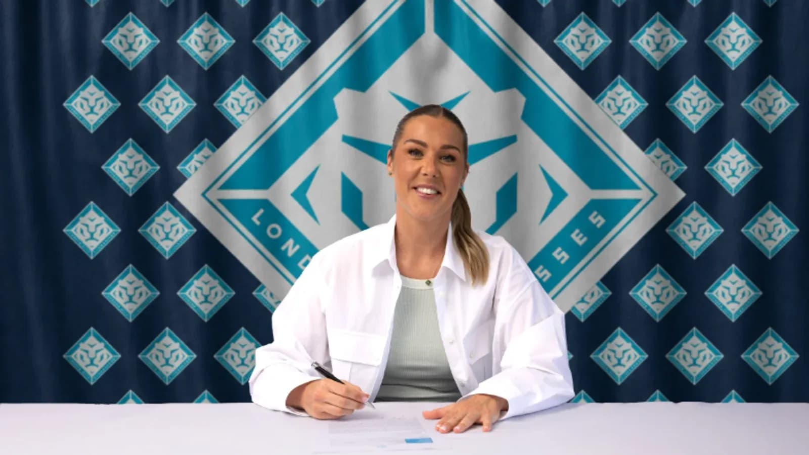 Jugadora firmando contrato en mesa con logo de equipo Jugadora firmando contrato en mesa con logo de equipo